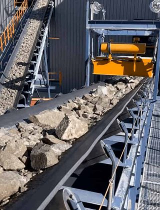 Banda transportadora industrial icobandas movilizando material a granel en una planta de producción